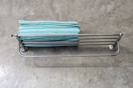 Blue towel is folded tidily on shelf in resort restroom or toilet prepared for guests.の写真素材