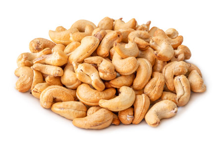 Roasted brown cashew nuts in stack are isolated on white background with clipping path.の写真素材