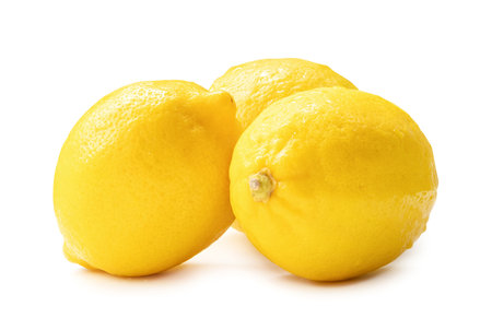 Three whole fresh beautiful yellow lemons in stack are isolated on white background with clipping path.の写真素材