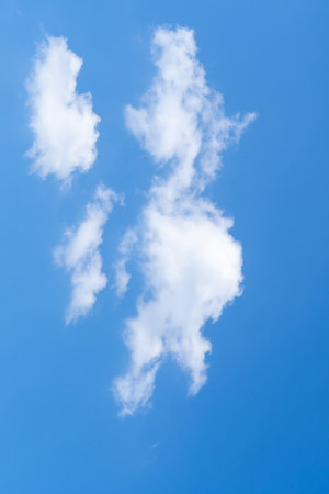 Low angle view of beautiful blue sky with strange shape of fluffy white clouds in the morning or afternoon on sunny day is used as natural background texture in decorative art work.の写真素材