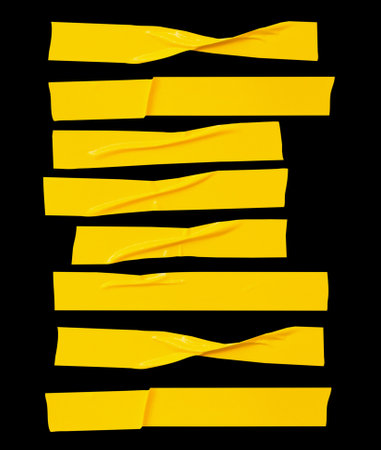 Top view set of wrinkled or crumpled yellow adhesive vinyl tape or cloth tape in stripes shape in horizon is isolated on black background with clipping path.の写真素材
