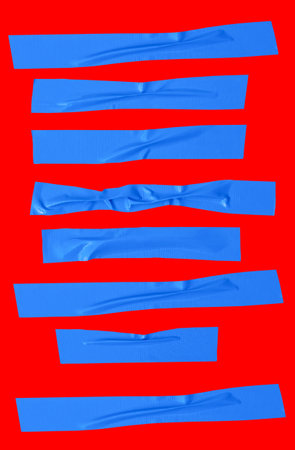 Top view set of wrinkled or crumpled blue adhesive vinyl tape or cloth tape in stripe shape is isolated on red background with clipping path.の写真素材