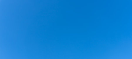 Low angle view and full frame of beautiful light blue sky without clouds in the morning or afternoon on sunny day is used as natural background texture in decorative art work.の写真素材