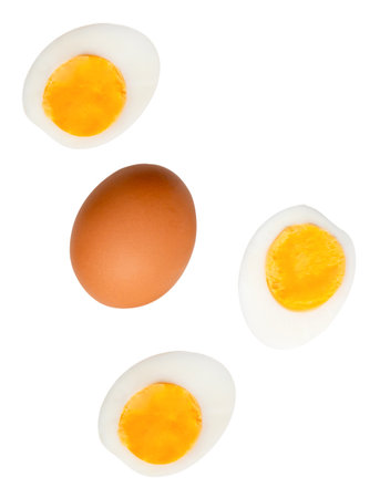 Top view set of raw brown chicken egg and cooked or boiled chicken eggs with egg yolk in three halves is isolated on white background with clipping path.の写真素材