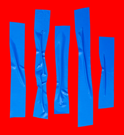 Top view set of wrinkled or crumpled blue adhesive vinyl tape or cloth tape in stripe shape is isolated on red background with clipping path.の写真素材