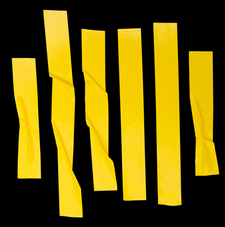 Top view set of wrinkled or crumpled yellow adhesive vinyl tape or cloth tape in stripes shape in vertical is isolated on black background with clipping path.の写真素材
