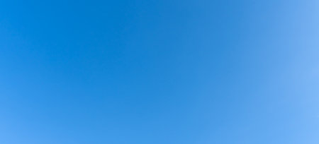Low angle view and full frame of beautiful light blue sky without clouds in the morning or afternoon on sunny day is used as natural background texture in decorative art work.の写真素材