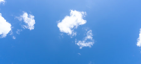 Low angle view and full frame of beautiful blue sky with strange shape of fluffy white clouds in the afternoon on sunny day is used as natural background texture in decorative art work.の写真素材