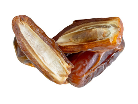 Ripe dried date palm fruits with halves in stack are isolated on white background with clipping path. Concept of iftar food in Ramadan month for Muslimsの写真素材