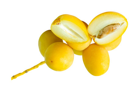 Fresh ripe yellow Barhi date palm fruits in small bunch with halves in stack are isolated on white...