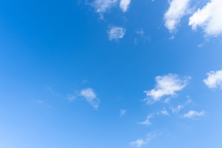 Low angle view and full frame of beautiful blue sky with strange shape of fluffy white clouds in the afternoon on sunny day is used as natural background texture in decorative art work.の写真素材