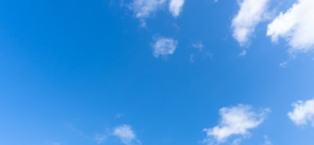Low angle view and full frame of beautiful blue sky with strange shape of fluffy white clouds in the afternoon on sunny day is used as natural background texture in decorative art work.の写真素材