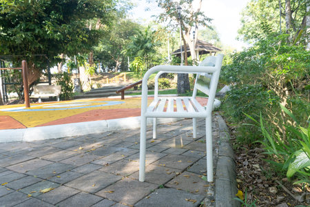 A white metal bench in public park.