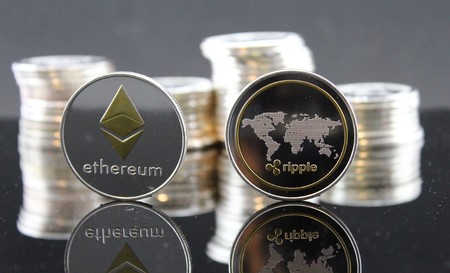 Ethereum ETH & Ripple XRP coins with cryptocurrency stacks in the backgroundのeditorial素材