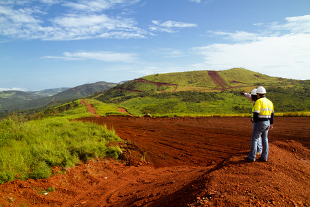 Mining construction workers outdoors, inspecting mine site on mountain topの写真素材