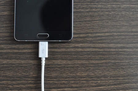 Smartphone Charging On Wood backgroundの写真素材