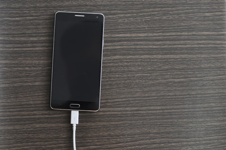 Smartphone Charging On Wood backgroundの写真素材
