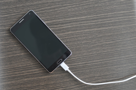Smartphone Charging On Wood backgroundの写真素材