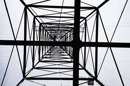 silhouette of high voltage electrical tower from belowの写真素材