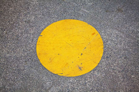 yellow circle painted on park walkwayの写真素材