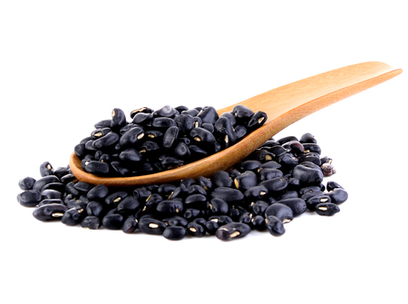 Black beans in spoon on white backgroundの写真素材