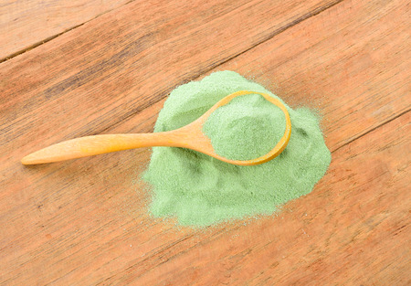 Japanese green tea in spoon on wooden tableの写真素材