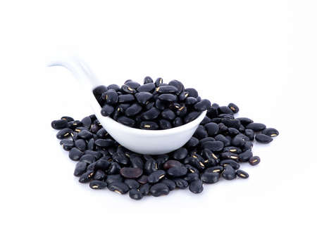 Dry black bean in white spoon  isolated on white background