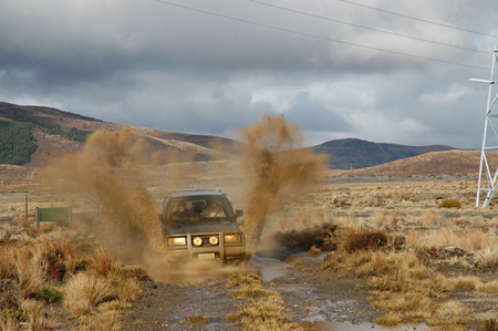 four wheel driving through mud puddle