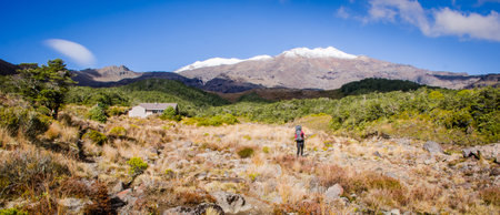 young woman trekking in alpine area with mountain backdropの写真素材