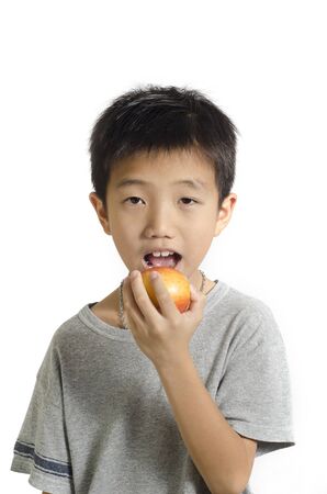 Small boy preparing to bite a big red apple isolated on white backgroundの写真素材