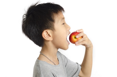 Small boy preparing to bite a big red apple isolated on white backgroundの写真素材