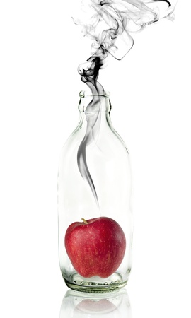 apple in Glass bottle with concept smokeの写真素材
