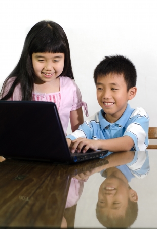 The boy and girl do homework on  laptopの写真素材