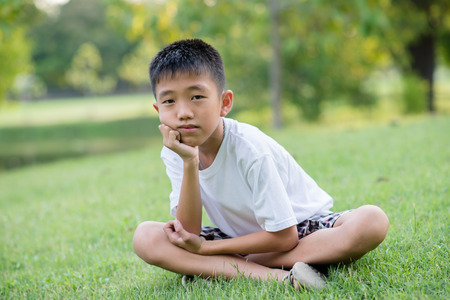Portrait of young boy with green grass の写真素材