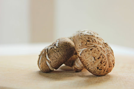 Fresh shiitake mushroom on wooden board with blurred background.の写真素材