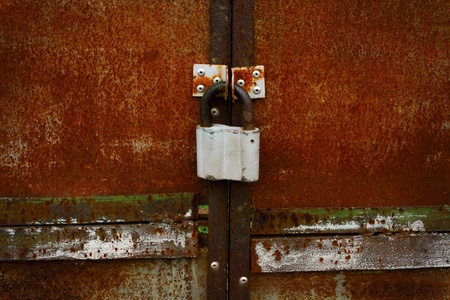 Rusty closed doors with old fashioned padlock