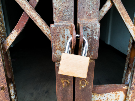 Gold master key, selective focus lock old and rusty iron gate