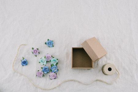 Brown gift box and rope decorate with blue tone paper flowers on muslin fabric with copy spaceの写真素材