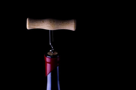 Corkscrew and bottle of wine.
Opening of a wine bottle with corkscrew.
Corkscrew and wine bottle on a dark background.の写真素材