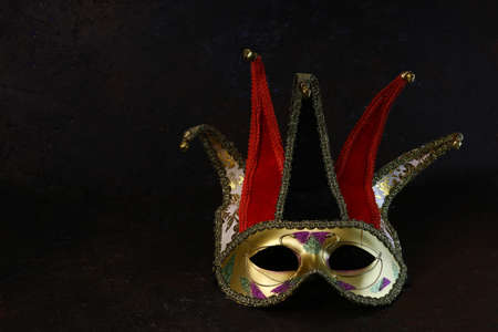 Carnival venetian Joker mask on dark background. Carnival mask front view.の写真素材