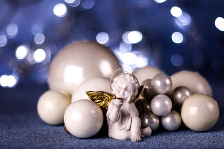 White Christmas tree toys and angel figure on blue background.Different sizes pearl balls.Christmas and New Year background concept.の写真素材