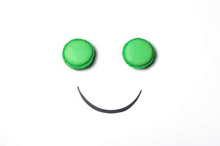 Smiley face concept. Smiley face made from macaroon on white background. Sweet smiley face metaphor.の写真素材