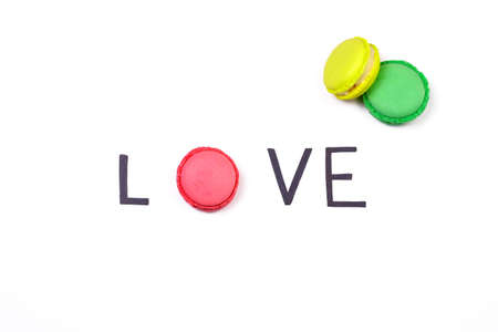 Love creative background. Hand lettering word love and sweet macaroon on white background.  Sweet love concept.の写真素材