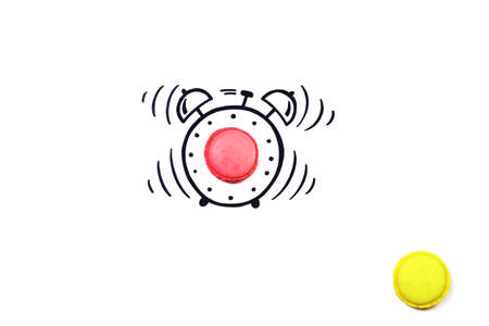 Creative alarm clock. Macaroon by alarm clock. Sweet time for macaroons.の写真素材