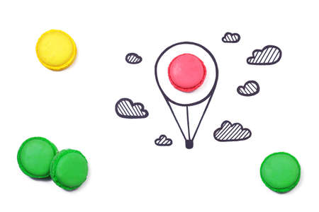 Macaroon and hand drawn air balloon and clouds on white background. Travel concept.の写真素材