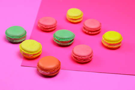 Different color macarons. Red, green, yellow and pink macaroons on purple and pink paper background.の写真素材