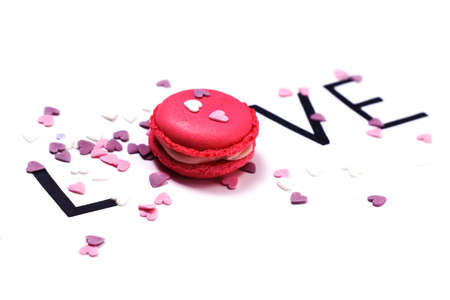 Love. Pink macaroon and hand drawn letters with little hearts. Sweet love concept.の写真素材