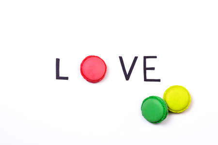 Love creative background. Hand lettering word love and sweet macaroon on white background.  Sweet love concept.の写真素材