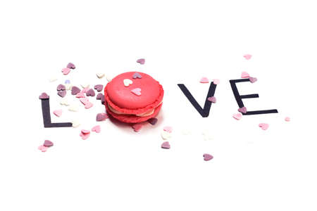 Love. Pink macaroon and hand drawn letters with little hearts. Sweet love concept.の写真素材