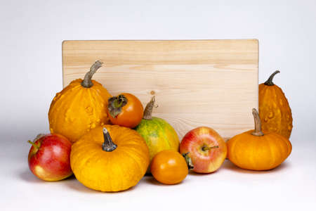 Autumn harvest fruits and wooden signboard isolated on white background. Apples, pumpkin,   and kinglet.の写真素材